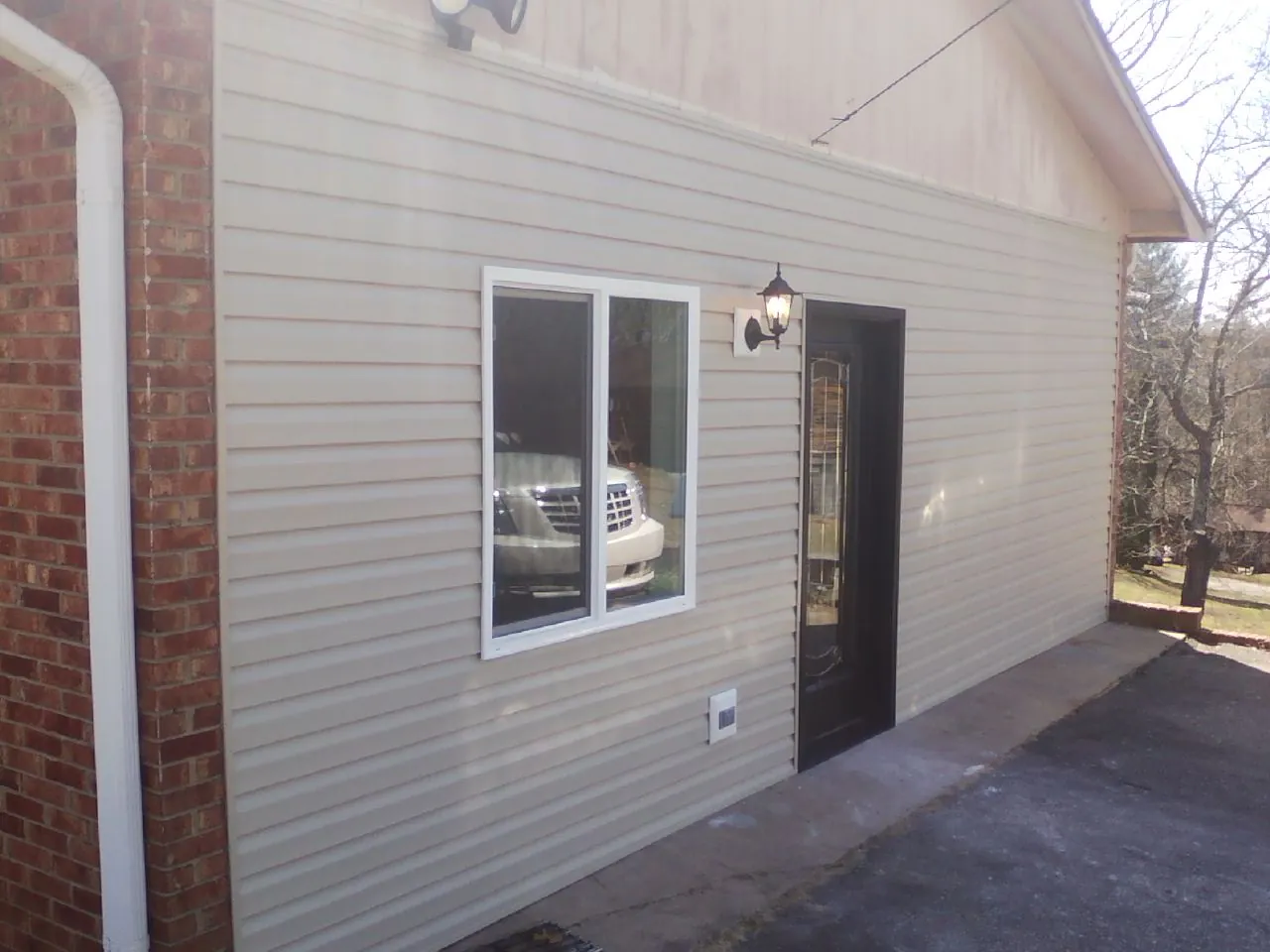 New vinyl siding and entry door on a room addition in Yates City