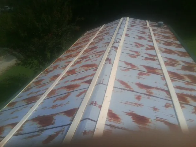 Rusted metal roof panels with new wood purlins before replacement — Storm Damage Roof Repair in Yates City by Roofing Brothers