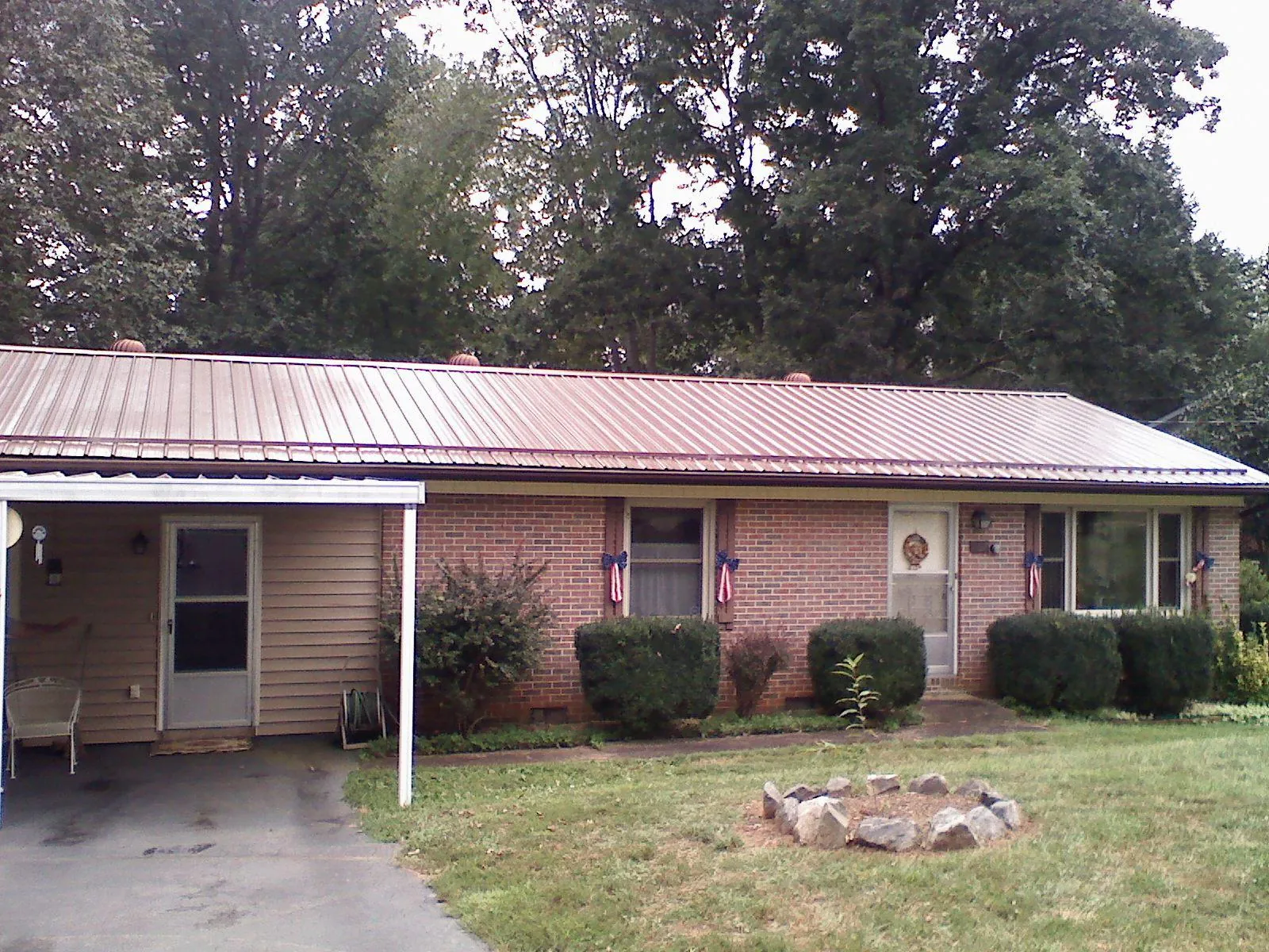 Bronze metal roof and carport on a brick ranch home — Roof Repair work by our crew in Yates City